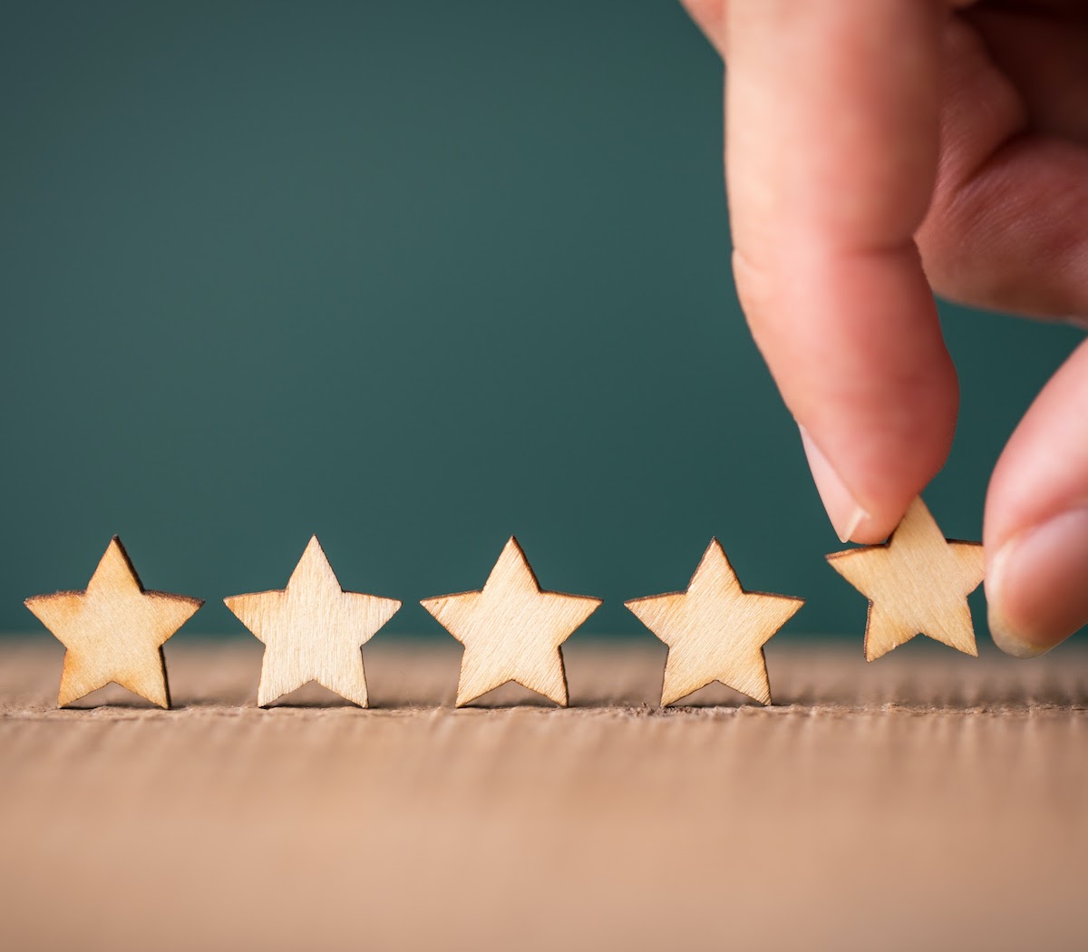 SEO reputation management: Hand putting wooden five star shape on table