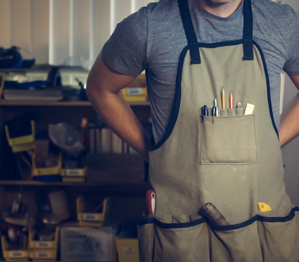 Man putting on apron with tools.
