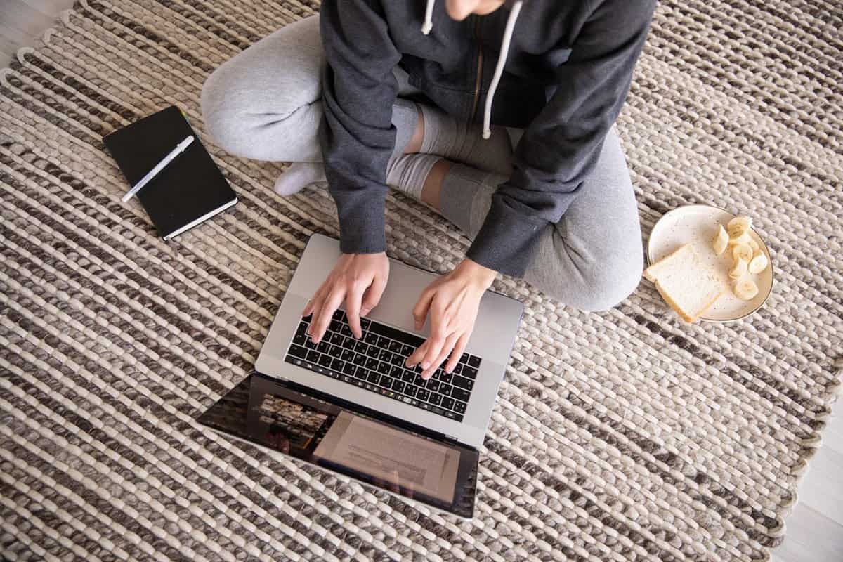 person sitting on ground working on laptop